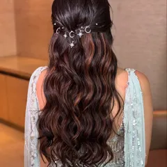 A dreamy half up hairstyle with soft, flowing waves. I added delicate moon and star charms to create a celestial, magical look perfect for a sangeet or reception night.