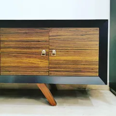 A close-up of a custom-designed cabinet in Villa 9/21B. The piece features a rich wood veneer, a sleek black frame, and vintage-style handles, showcasing our attention to detail in product and furniture design.