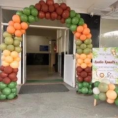 We create welcoming entrances that set the party theme from the very first step. This balloon arch uses safari-inspired colors like olive green, brown, and orange to greet guests for a jungle birthday party.