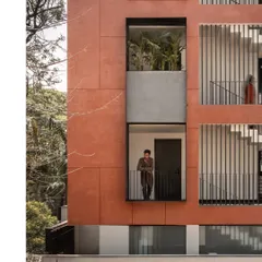 The design incorporates recessed balconies and large windows, breaking up the monolithic facade. These openings not only provide light and air but also offer tenants a direct connection to the tree canopy and the outdoors.