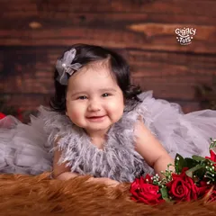 Six months of snuggles, smiles, and sunshine! This beautiful baby girl is surrounded by roses in this classic and elegant milestone portrait.
