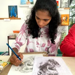 A teen student uses the grid method to create a detailed portrait sketch. This foundational technique is a key part of our curriculum, helping students achieve accurate proportions and realistic details in their drawings.