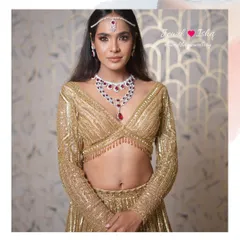 A glamorous look for a Sangeet night. This model wears a layered diamond and ruby necklace set with a matching mathapatti, paired with a dazzling golden lehenga.