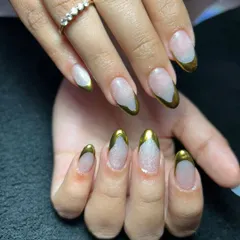 This design features a modern take on the French manicure using a bold, liquid gold chrome for the tips. The metallic finish against the natural base creates a chic and sophisticated look.