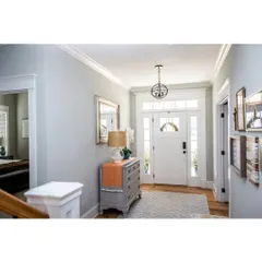 A bright and classic entryway with detailed molding around the door and ceiling. These traditional architectural details add a timeless elegance to the home.
