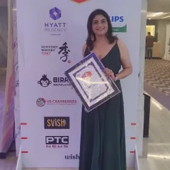This is a photo of me at the awards night, holding my certificate against the backdrop of event sponsors like Hyatt Regency and PTC News. It was a proud moment for my home bakery.