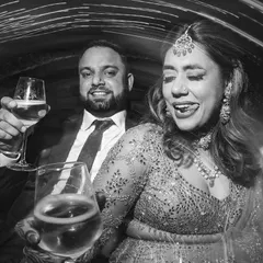 A fun and candid black and white shot of the couple toasting to their new life together. Their expressions are full of joy and a little bit of mischief.