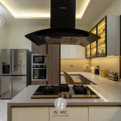 A perspective from the island cooktop, looking towards the built-in appliances. The island chimney acts as a strong focal point while ensuring the kitchen remains fresh and smoke-free.