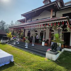 This wide view shows how we integrate our decor with the venue. The traditional floral hangings and arrangements on the steps of this beautiful Malnad home create a cohesive and festive look for the wedding.