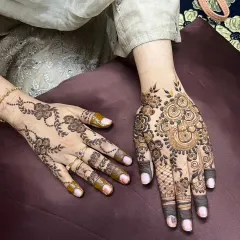 This shows two different styles side-by-side. One hand has a simple, delicate floral vine, while the other features a more complex Indo-Arabic design, showing the range of floral art.