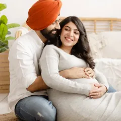A cozy and intimate portrait of an expecting couple in our boho-themed studio. The warm smiles and gentle embrace perfectly capture the excitement of their journey.