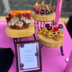 A close-up of the 'Squid Game' themed dessert station, featuring 'Churros of Fate' and 'Tiramisu Shots of Time'. The custom menu and themed toppers show how every detail is designed to fit your party's story.