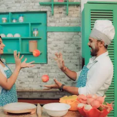 Love is cooking up something beautiful! This couple shares a laugh in a quirky kitchen setting, a perfect example of a themed pre-wedding shoot that reflects shared interests and creates fun, natural interactions.