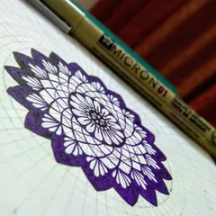 A work-in-progress shot of a violet mandala. You can see the faint pencil grid lines underneath, which are essential for keeping the design symmetrical. This is the foundation we learn to build in my workshops.