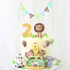 A delightful jungle safari cake perfect for a child's second birthday. This design is packed with fun, featuring adorable, handmade fondant animals like a lion, zebra, and monkey, all ready for a jeep adventure.