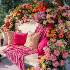 The perfect photo spot for a Mehendi, featuring a classic white bench completely enveloped in a cascade of multi-colored roses and florals. This creates a lush, romantic, and incredibly photogenic seating area for the bride.