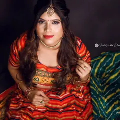 This top-down angle showcases the complete festive look, from the maang tikka to the soft waves in the hair. The makeup is designed to be bold and camera-ready, perfect for a celebratory photoshoot.