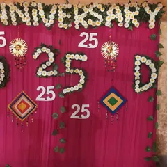 A custom backdrop I created for a 25th anniversary party. I used white flowers to spell out 'ANNIVERSARY' and create the number '25' against a bright pink curtain.