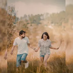 A happy, carefree moment of the couple running through a field in Uttarakhand. This shot captures pure joy and movement, showing that pre-wedding photos can be dynamic and full of life.