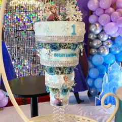 A Frozen-themed chandelier cake for a magical first birthday. This design combines the elegance of a hanging cake with the fun of a beloved Disney movie, complete with shimmering details and characters.