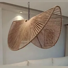 A large, sculptural pendant light made from intricately wrapped jute rope. Its unique, free-flowing shape makes it a work of art, perfect for adding texture and a bold design element to spaces with high ceilings.