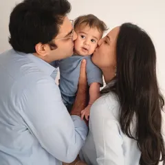 A "kiss sandwich" is one of my favorite poses for family photos with a baby. This classic studio shot captures the love and affection surrounding their little one.