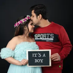 Sharing the wonderful news with a classic "It's a Boy" slate. This is a fun and timeless way to announce the gender of your little one during your maternity shoot.