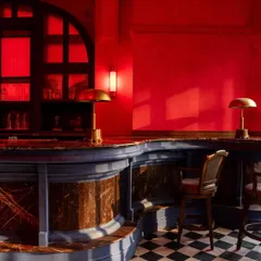 A detail of the bar, where the contrast of the blue base, marble top, and red surroundings creates a rich, jewel-toned palette.