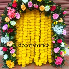 A vibrant and traditional ready-to-install makhar, perfect for Haldi ceremonies or Ganpati festival decor. This backdrop features dense yellow marigold garlands framed by a colorful arch of artificial roses, creating a classic festive look.
