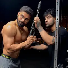 Attention to detail is everything. I'm here with my client, making sure his form on the tricep pushdown is precise to target the muscle effectively.