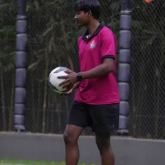 Our coach prepares for a personal training session, holding a ball and ready to demonstrate techniques. These sessions are tailored to the individual player's needs.