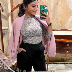 A close-up of my pink blazer look. Draping a blazer over your shoulders is a styling trick that adds an effortless layer of chic to any professional outfit.