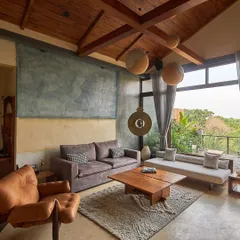 In the heart of Bangalore, we designed the Magnolia penthouse to be an urban oasis. This living space, with its natural timber roof and pigmented cement walls, opens up to a lush terrace, blurring the line between indoor comfort and outdoor serenity.