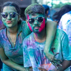 A couple enjoying the vibrant and playful atmosphere of the Holi party. It's all about letting loose and having fun.