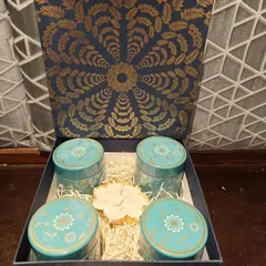 A classic and elegant gift box for corporate clients. This deep blue and gold box contains four matching turquoise tins filled with treats and a central decorative diya, striking the perfect balance between professional and festive.
