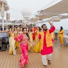 The bride and groom leading their crew in a dance on the deck of the Cordelia Cruise. A Haldi celebration on the Arabian Sea is a vibe of its own.
