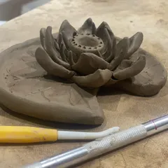 A delicate lotus flower sculpted from clay. This piece was made during one of our clay handbuilding workshops, showing the intricate details you can achieve.