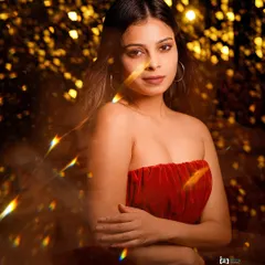 Playing with light and reflections. I used a prism to create these golden flares, adding a magical and festive layer to this portrait in a red velvet top.
