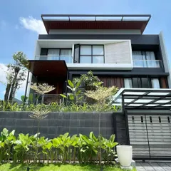 This modern home features a tiered landscape design. We used a retaining wall to create different levels, planting lush greenery at the base and more delicate trees on the upper tier to soften the contemporary architecture.