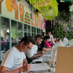 A "Paint & Express" workshop in full swing. Everyone is focused on their canvas, creating something uniquely their own.