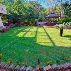 A wide view of a finished residential garden, complete with a perfectly installed lawn, a brick border, and a gazebo area in the background. This is the kind of beautiful, functional outdoor living space I love to create.
