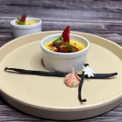 A perfectly torched Crème brûlée, a classic French dessert with a rich custard base and a contrasting layer of hard caramel.