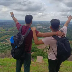 Two friends at the peak of Nijagal Betta, celebrating their climb. These treks are a great way to bond and challenge yourselves.