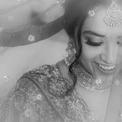 A classic black and white bridal portrait, with the bride's happy expression peeking through her sparkling veil. It's soft, dreamy, and timeless.