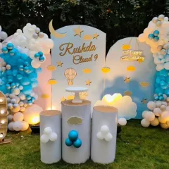 A dreamy "Cloud 9" themed party for Rushda, set up outdoors. The decor features shades of blue and white to mimic the sky, with cloud-shaped backdrops and hot air balloon details.