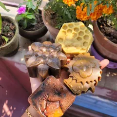 A handful of my different facial soaps. You can see the variety in shapes and ingredients, from coffee-based bars to honeycomb designs, each crafted for a specific skin benefit.
