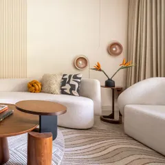 Pops of color from the cushions and flowers break the neutral palette, adding personality and life. The 3D wall art and fluted panels provide subtle texture, maintaining the minimalist aesthetic while adding visual interest.
