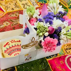 Our 'Garden of Love' hamper is a Diwali favourite. It pairs a hand-piped 'Happy Diwali' bento cake with a stunning fresh flower arrangement of tuberoses, carnations, and lotus buds, presented in a convenient carry box.