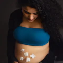 A creative and sweet way to announce a baby boy. The little cotton flowers on the baby bump are a delicate touch in this modern, casual maternity portrait.
