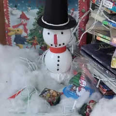 A close-up of our Christmas decorations, featuring a cute snowman nestled in cotton "snow" among the books.